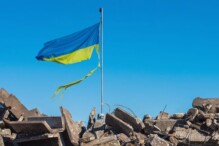 A Ukranian flag waves on top of a destroyed building in Ukraine