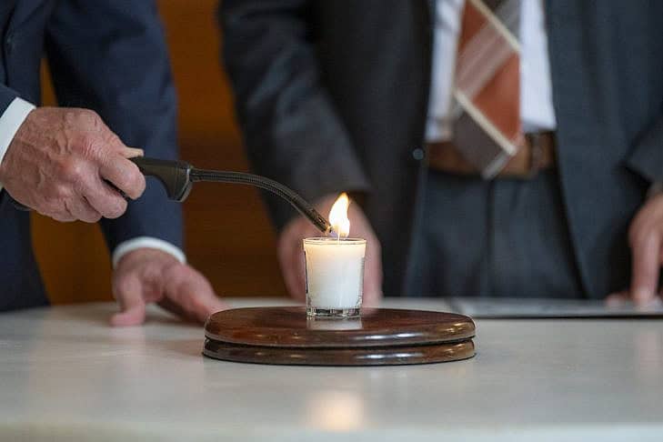 President Joe Biden lights a candle as he, First Lady Jill Biden and Rabbi Aaron Alexander of Adas Israel Congregation participate in a ceremony to commemorate the one-year anniversary of the Hamas terrorist attacks in Israel, Monday, October 7, 2024, in the Blue Room of the White House. (Official White House Photo by Adam Schultz)