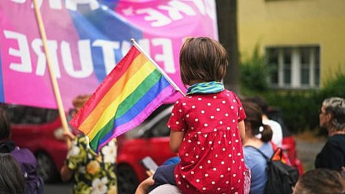 LGBTQIA Queer Pride Little kid sit mother shoulder. Gay protest against no homophobia. Family walk lgbt pride parade. Child watch lesbian strike. Bi parent show us csd fest daughter. Peaceful rally Girl hold rainbow flag