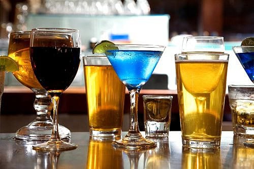 Beer Wine Cocktails Drinks Alcohol Happy Hour An assortment of various alcoholic drinks back lit on a bar.