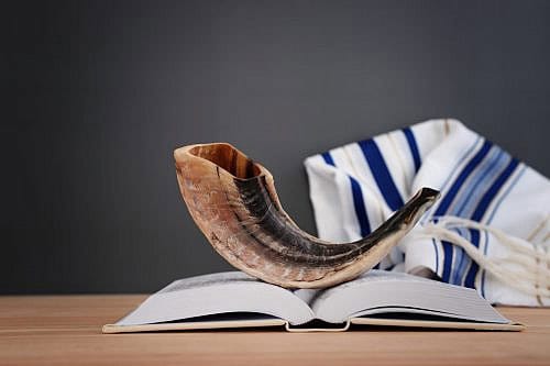 Yom Kippur Shofar image of shofar (horn) on white prayer talit. Rosh hashanah (jewish New Year holiday), Shabbat and Yom kippur concept