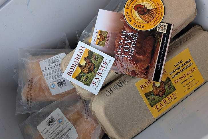 Robariah Farms Chicken and Eggs, Ready for Delivery Packaged Robariah Farms chicken and cartons of eggs in a cooler, alongside a Shanah Tova card and a Vote With Your Chicken sticker.