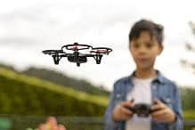 Kid flying drone Concentrated boy flying his toy drone with remote control in his hands in a park. Selective focus